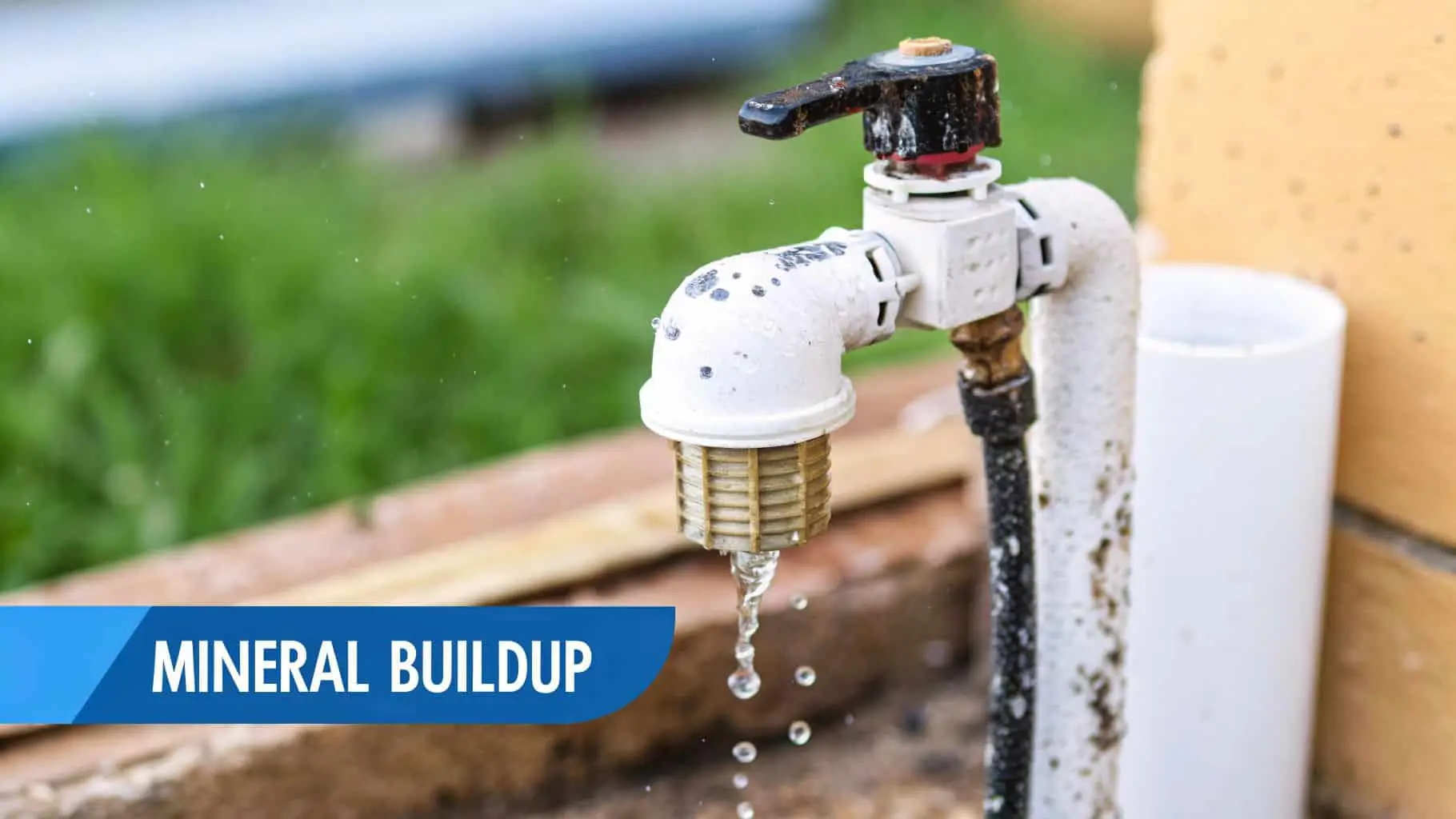 An outdoor water faucet with significant mineral buildup is dripping water, highlighting common hard water issues.
